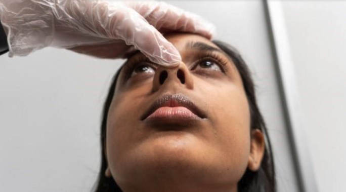 Nasal examination technique showing illumination of nasal cavity