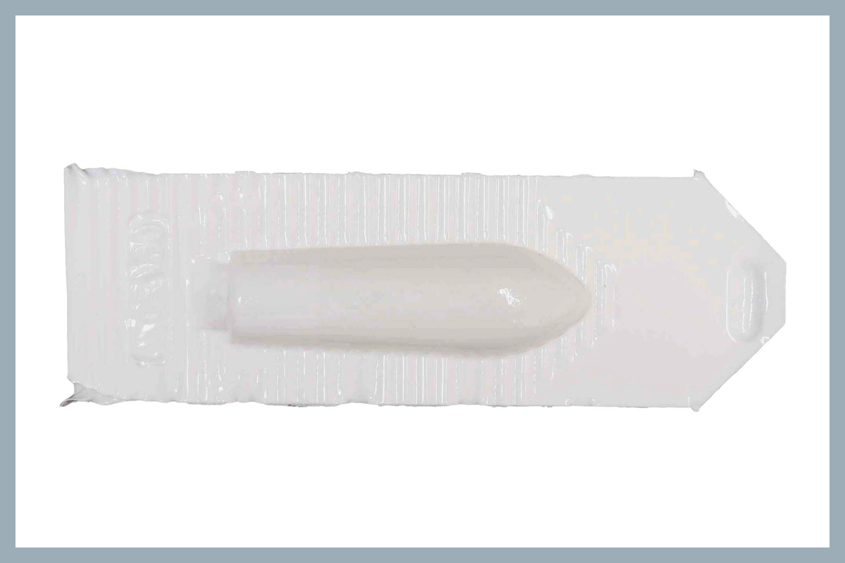Small, bullet-shaped suppository in white plastic packaging